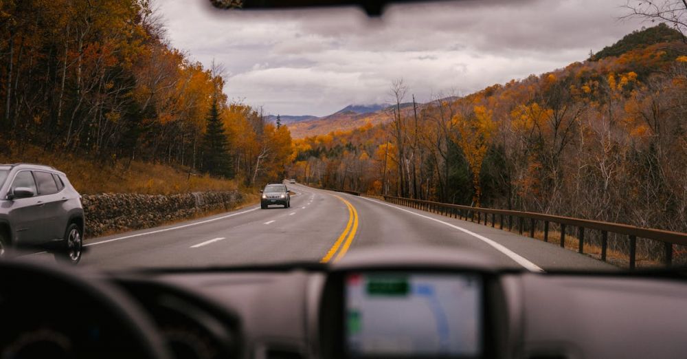 Day Trip Transport - Car riding on highway through autumn forest